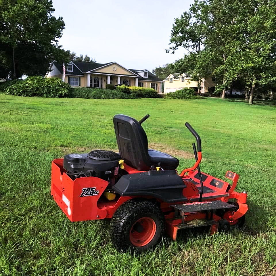 Zero-turn mower on a freshly cut lawn in front of a Central Florida home